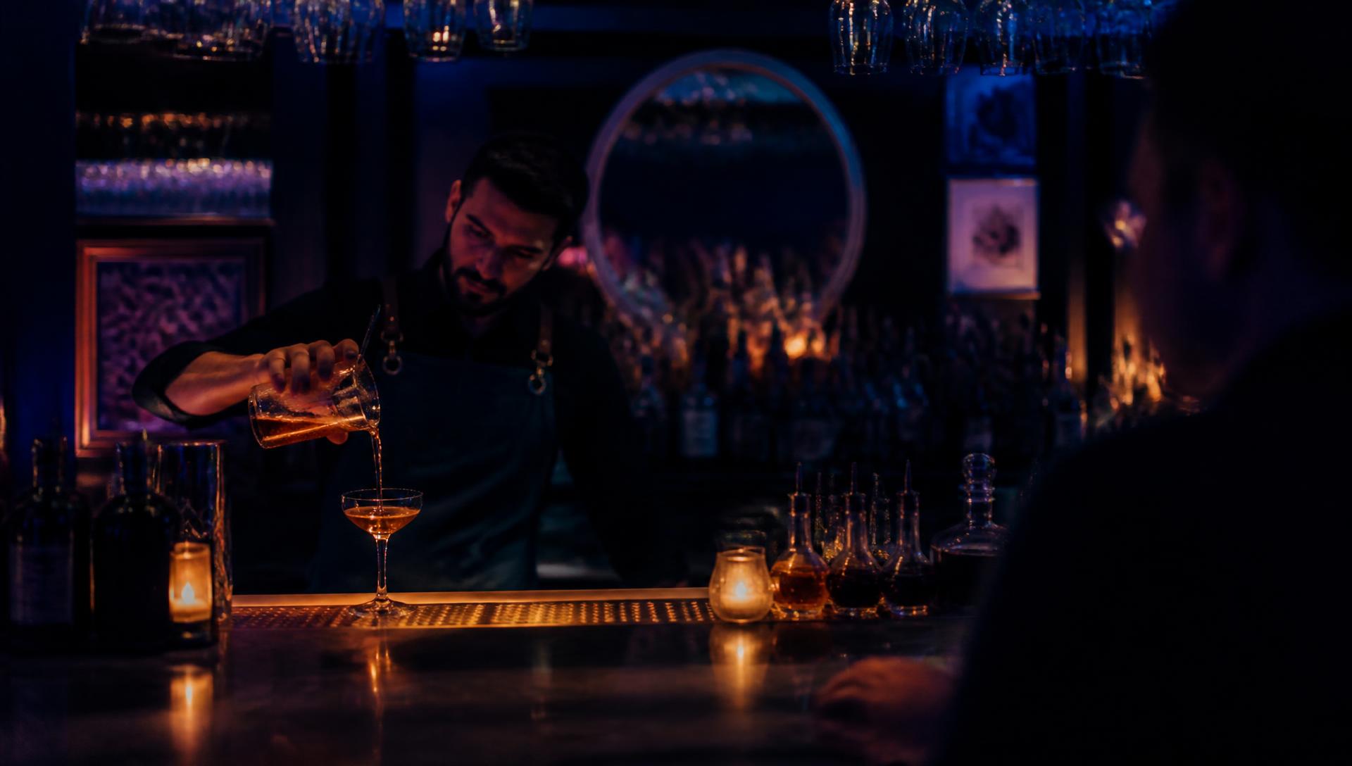 Bartender serving drinks at a busy bar while Tabz closes patrons' tabs automatically